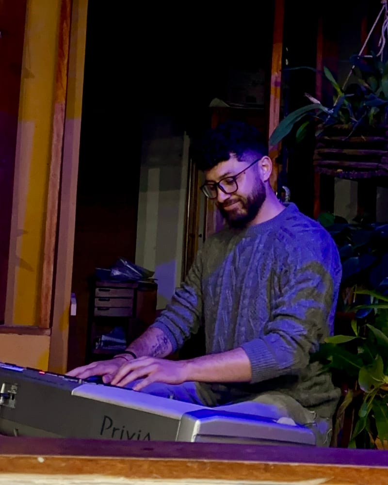 Juan Pablo playing a digital piano at home in the evening